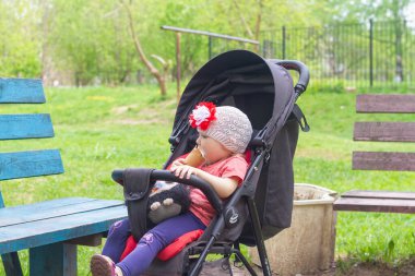 Sevimli küçük kız 2 yaşında parkta tatlı dondurma yiyor ve ağzını ve yüzünü yapışkan dondurmayla boyuyor..