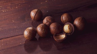 Kahverengi ahşap bir masada Macadamia fındıkları.