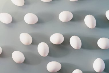 Gri bir arka plan üzerinde beyaz tavuk yumurta.