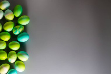 Paskalya kompozisyonu yeşil ve mavi Paskalya yumurtaları gri arka planda, hassas bir Paskalya arkaplanı.