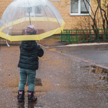 Mavi ceketli şirin bir kız soğuk sonbaharda yürür ya da yağmurlu bir havada, sarı bir şemsiye altında kasabanın sokaklarında..