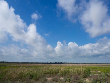 İlkbaharın başlarında bir tepenin ardında bozkır bir köy ve her şeyden önce beyaz bulutlu mavi bir gökyüzü var. .