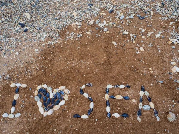 The inscription, I love the sea laid out with shells on the sand-shell beach.