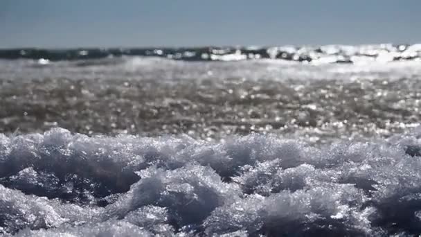 冰雪飘浮在海浪上 在靠近海岸的海面上摇曳 在阳光下闪闪发光 美丽的自然背景 — 图库视频影像