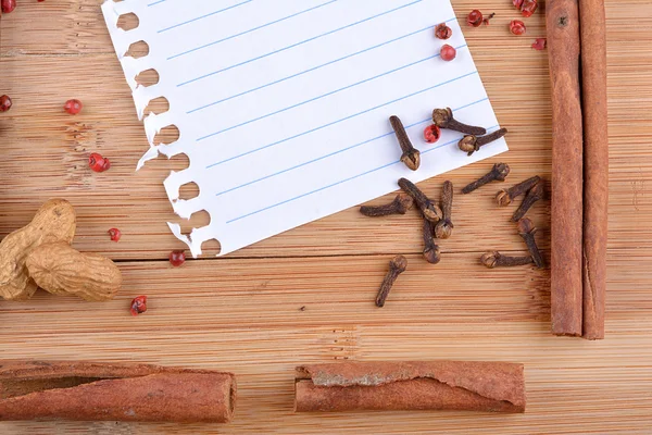 Papierbogen mit Gewürzen auf Holz — Stockfoto
