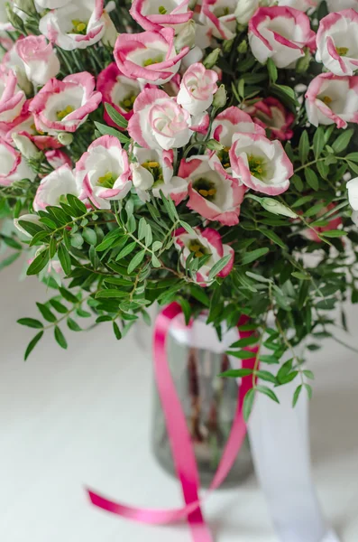Beautiful romantic bouquet of pink and white eustoma flowers with satin tape in a vase on a white background — Stock Photo, Image