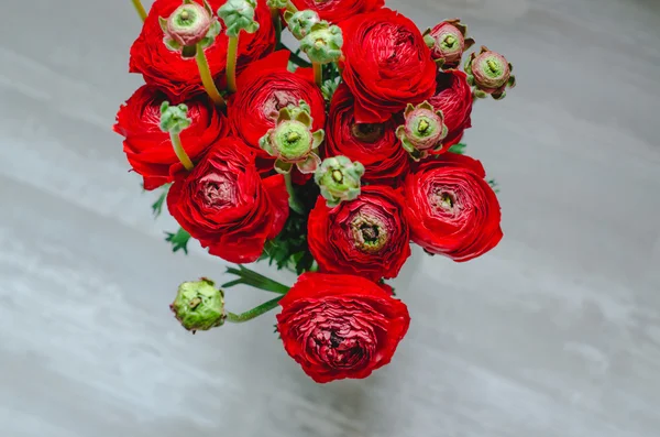 Букет з різнокольорового ранункулюса з масляної чашки червоні квіти на дерев'яному русичному тлі — стокове фото