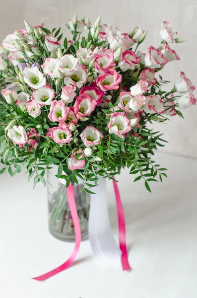 Bellissimo bouquet romantico di fiori di eustoma rosa con nastro di raso in vaso su sfondo bianco — Foto Stock