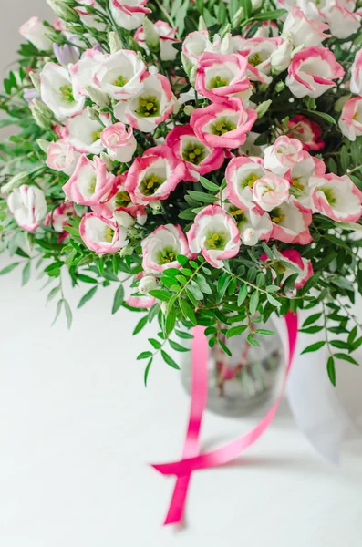 白い背景の上に花瓶でサテンのテープでピンクと白のトルコギキョウの花の美しいロマンチックな花束 — ストック写真