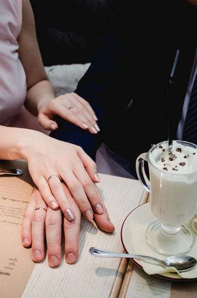 Just married couple hold hands and showing up wedding ring in cafe — Stock Photo, Image