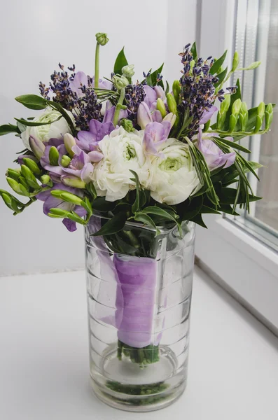 Bellissimo bouquet primaverile di fiori di nozze ranuncolo ranuncolo, fresia, lavanda in vaso con nastro viola. Colori pastello viola, verde. Stile rustico. Sfondo bianco . — Foto Stock