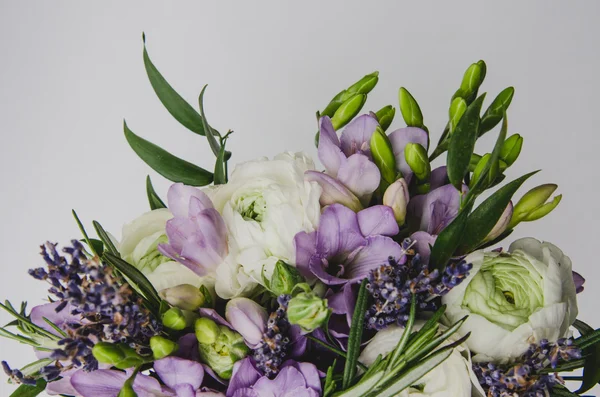 Bellissimo bouquet primaverile di fiori di nozze ranuncolo ranuncolo, fresia, lavanda in vaso con nastro viola. Colori pastello viola, verde. Stile rustico. Sfondo bianco . — Foto Stock