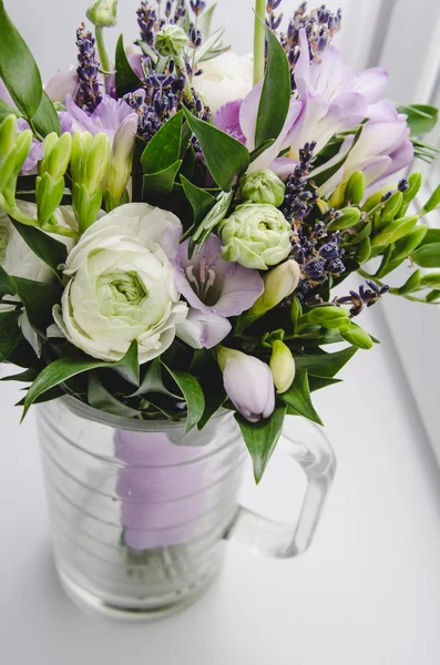 Bellissimo bouquet primaverile di fiori di nozze ranuncolo ranuncolo, fresia, lavanda in vaso con nastro viola. Colori pastello viola, verde. Stile rustico. Sfondo bianco . — Foto Stock