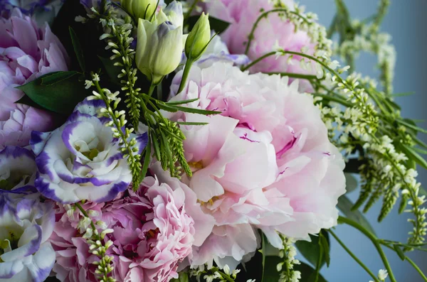 Rich bunch of pink peonies peony and lilac eustoma roses flowers. Rustic style, still life. Fresh spring bouquet, pastel colors. Background.