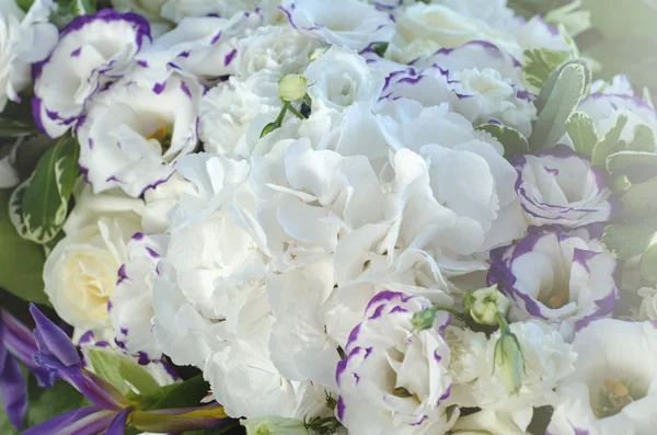 Ricca ortensia bianca, delicate rose crema, eustoma viola, foglie lussureggianti in una bella decorazione. Grande mazzo di fiori freschi sulla tavola nuziale di lusso. Sfondo estivo . — Foto Stock