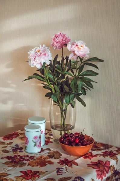 Натюрморт со свежим букетом белых, розовых пионов в стеклянной вазе, темные вишни на столе, винтажная печать скатерти цветы и фуит, цвет марсалы. Сельский стиль. Цветочные сцены — стоковое фото