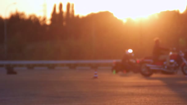 Motorradfahrstunden Moto-Gymkhana-Motorradfahrer bei Sonnenuntergang außer Fokus Hintergrundschleifen — Stockvideo