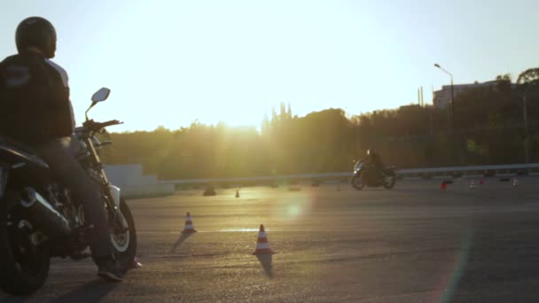 Motociclistas competem na faixa de tempo de velocidade de passagem com o temporizador no pôr do sol moto competição Gymkhana — Vídeo de Stock