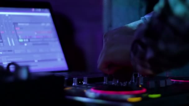 Hands of DJ which mixes music tracks PC mixer in nightclub 5 loop video — ストック動画