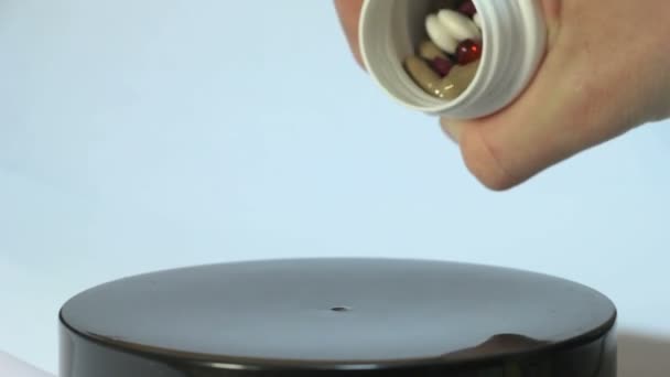 Mehrfarbige Pillen aus dem Glas auf einem Drehgestell 2 gegossen — Stockvideo