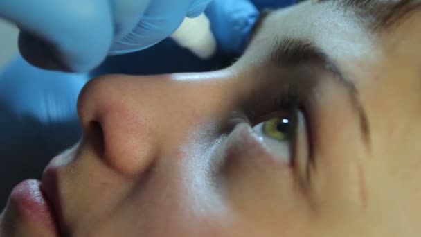 Доктор капает глазные капли девушка — стоковое видео