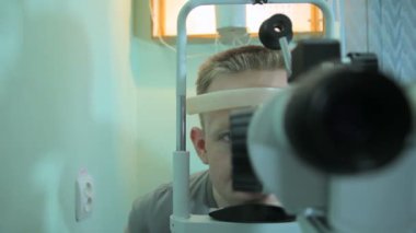 Doktor optometrist göz doktoruna hastaya 2 özel bir cihaz yardımı ile retina inceliyor