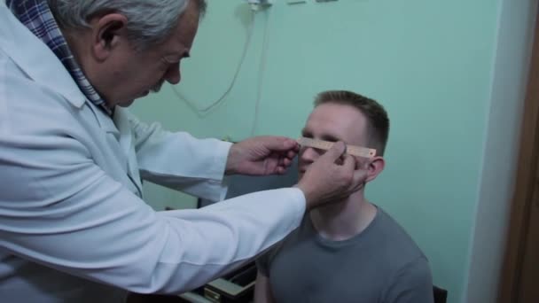 Λίπετσκ, Ρωσική Ομοσπονδία - 15 Μαρτίου 2015: «ημέρα της υγιή μάτια» στην κλινική 9, ο γιατρός optometrist Οφθαλμίατρος Anatoly Πέτροβιτς ελέγχους όραμα νεαρός άνδρας που ήρθε να την ανοικτή εγγραφή — Αρχείο Βίντεο