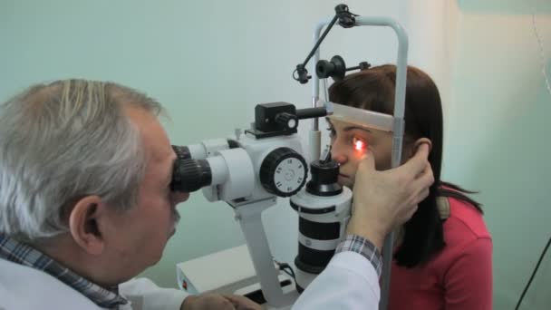 Lipetsk, Federação Russa - 15 de março de 2015: "Dia de olhos sãos" na clínica 9, o oftalmologista optometrista médico Anatoly Petrovich verifica a visão e a retina de uma jovem mulher em uma especial — Vídeo de Stock