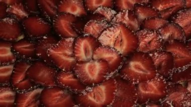 Pek çok kırmızı dilim taze çilek, hızla döner saat yönünün tersine