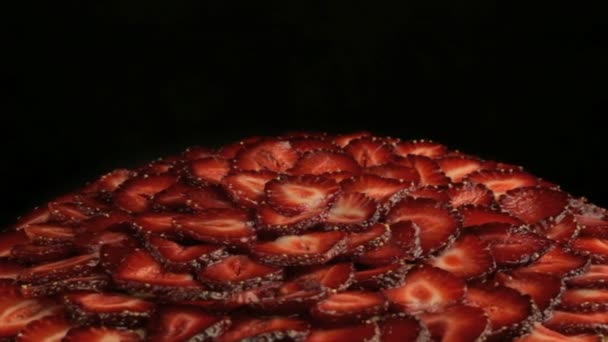 Çok lezzetli kırmızı çilek pasta parçalar üzerinde yavaş yavaş siyah bir arka plan üzerinde saat yönünün tersine döndürür — Stok video
