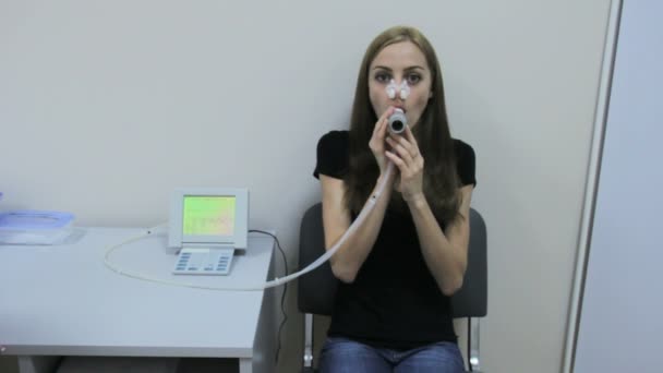 Meisje blaast in de buis van de spirometer — Stockvideo