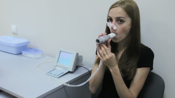 Mädchen atmet in Spirometerrohr mit geschlossenem Zeh, um den Sauerstoff in der Lunge zu kontrollieren — Stockvideo