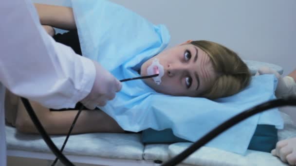 Лікар робить ендоскопію в роті молодої дівчини, гастроскопічна трубка — стокове відео