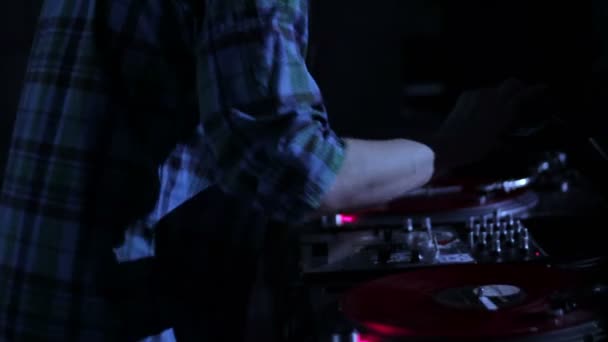 DJ царапает виниловые пластинки и микширует их на дискотеке в Nightclub loop video — стоковое видео