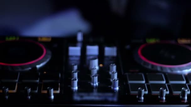 DJ-mixer i klubben i strålar av ljus på bakgrunden till dansande Dj loop video — Stockvideo