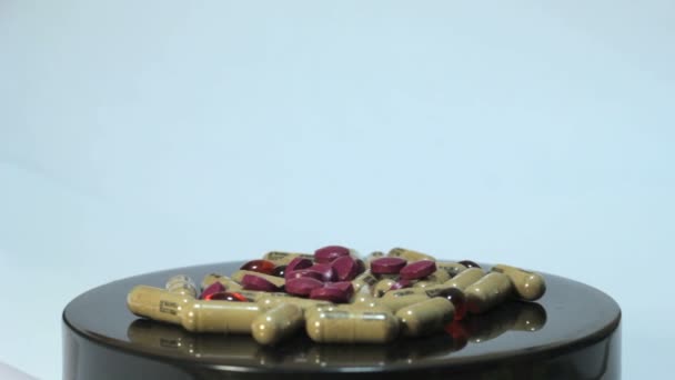 Multi gekleurde pillen gegoten uit de pot op een roterende rek 3 — Stockvideo