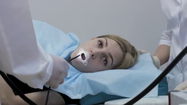 Врач поместил эндоскоп в рот девушки — стоковое видео