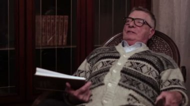 Dedesi bir sallanan sandalyede onların elinde bir kitapla