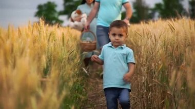 Küçük çocuk yaz tarlasında kız kardeşi ve ailesiyle ağır ağır yürüyor.