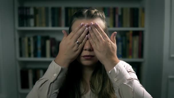 Portrét mladé bělošky, která zavírá oči rukama v interiéru — Stock video