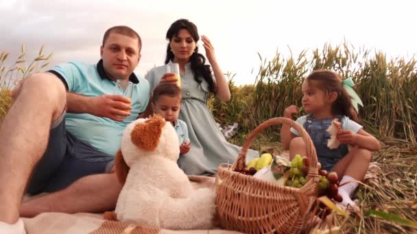 Ritratto di una felice famiglia caucasica con due bambini che fanno un picnic in un campo di grano a slowmo — Video Stock