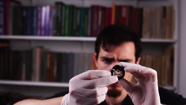 Retrato de orfebre que examina el anillo de oro a través de lupa y sorprendentemente levanta las cejas — Vídeos de Stock