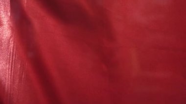 Yakın çekim ve ağır çekimde kırmızı dalgalı bir bayrak.