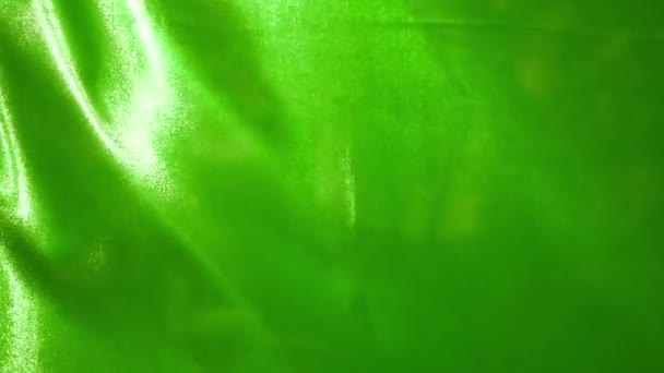 閉じるとスローモーションで風になびく緑の絹の布 — ストック動画