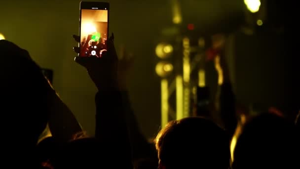 Közelkép Man kézfogás mobil és videó zenei koncert éjszakai klubban slow mo — Stock videók