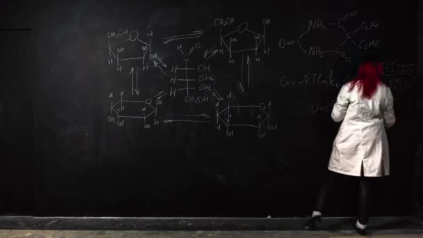 Een professor in labjas schrijft scheikunde formules op een schoolbord in time lapse — Stockvideo