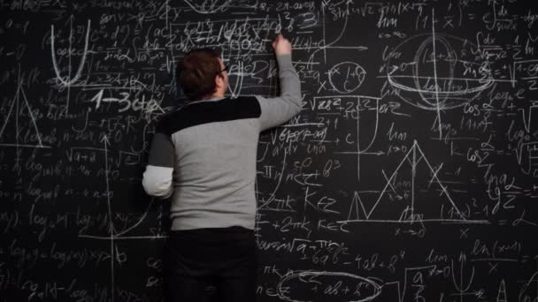 Student solves the equation at the blackboard and makes a mistake then corrects it — Stock Video