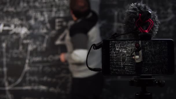 Крупный план онлайн урока математики, записанного на камеру смартфона на штативе — стоковое видео