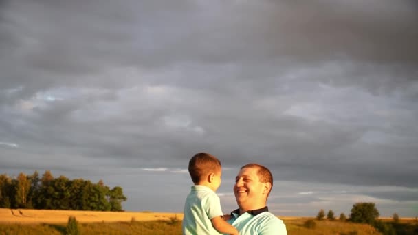 Ayah sedang menggendong anak kecilnya dalam pelukannya di ladang gandum — Stok Video