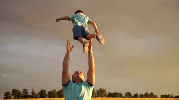 Père heureux jette son fils dans les airs et l'attrape sur le terrain — Video